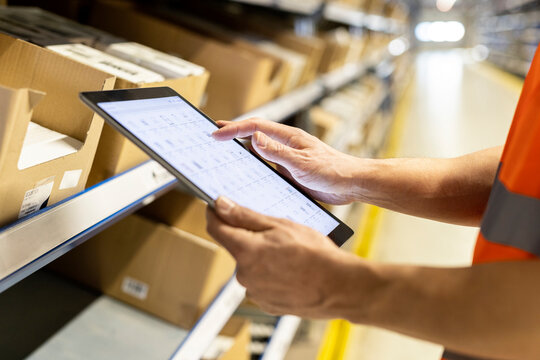 Worker checking list through tablet PC in warehouse