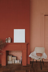 Elegant Scandinavian hygge style home living room interior. Cozy chair, fireplace, blank picture frame, red walls © Floral Deco