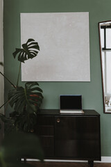 Laptop computer on vintage console table, tropical plant monstera. Aesthetic elegant blog, online shop, store, social media
