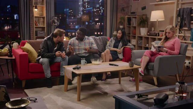 Television Sitcom Concept. Four Diverse Friends having Fun in the Living Room. TV Show Funny Sketch about Explaining Simple Thing. Comedy Series Playback on Network Channel or Streaming Service.