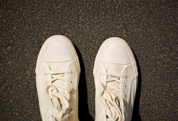 New white gym plimsolls on the pavement.