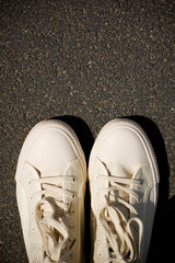 New white gym plimsolls on the pavement.