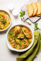 Spring Chicken casserole made with potato, leek, green pea,  white wine and Spring greens, mint and green onion. Bread. Top view. Vertical image.