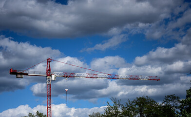 construction crane on the background of clouds during sunny day.