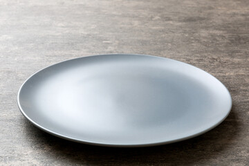 Perspective view of empty grey plate on cement background. Empty space for your design