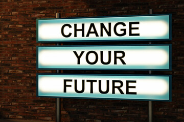 Change Your Future. Black letters on a light box. The illuminated sign placed in front of a red brick wall. New job, new opportunity, positive emoption and hope concept. 3D illustration