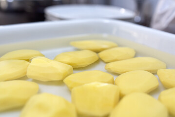 pommes de terre épluchées dans un bac rempli d'eau