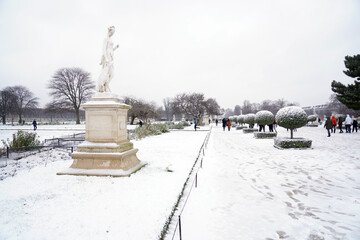 People walking and enjoying in a snowy day inside the park and garden.