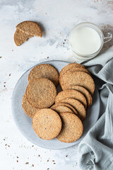 Plate with tasty crackers with sesame and flax seeds on grey background. Top view.