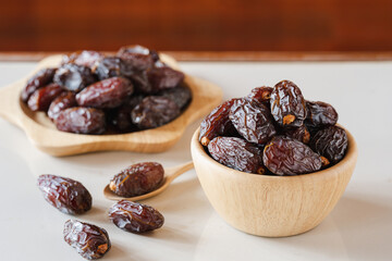 Medjool dates in a wooden container on the table. It is the king of dates with the largest size.