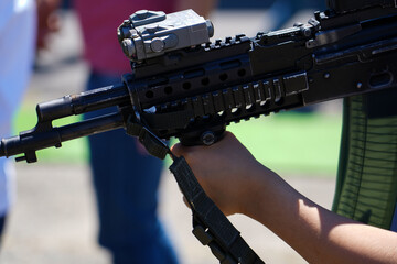 civilian trying a weapon at a military trade fair in May 2022, Bucharest, Romania. detail of the...