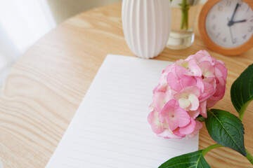 A blank letter paper with colorful Hydrangea flowers and vase on a wooden table. wedding, bridal and Birthday celebration image background. Seasonal flower interior decoration.