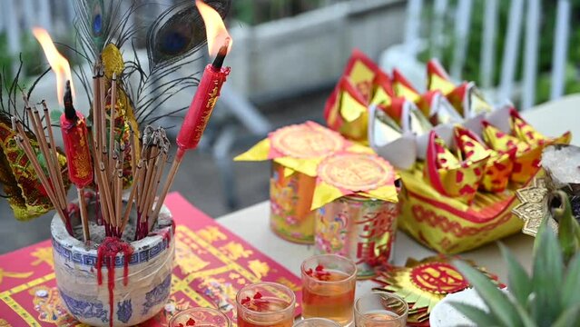 Chinese New Year offerings, incense sticks and candles placed on the table