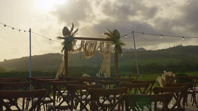 The wedding arch stands on the edge of the mountain. Boho style wedding decorations. Clouds in the background