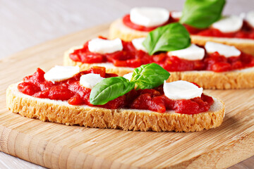 Italian appetizer bruschetta with Tomato sauce, Mozzarella and fresh Basil on a plate