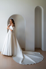 Beautiful bride in a luxurious wedding dress on white background