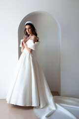 Beautiful bride posing in wedding dress in a white photo Studio.