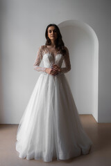 Beautiful bride in a magnificent white wedding dress of tulle with corset lacing and long beauty hair