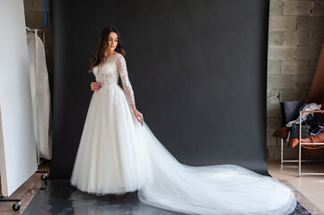 Full length portrait of young beautiful woman wearing white wedding dress. Elegant bride standing...