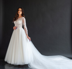 Fototapeta na wymiar Full length portrait of young beautiful woman wearing white wedding dress. Elegant bride standing and posing