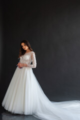 Fototapeta na wymiar Full length portrait of young beautiful woman wearing white wedding dress. Elegant bride standing and posing