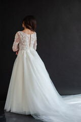 Full length portrait of young beautiful woman wearing white wedding dress. Elegant bride standing and posing