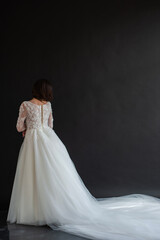 Full length portrait of young beautiful woman wearing white wedding dress. Elegant bride standing and posing