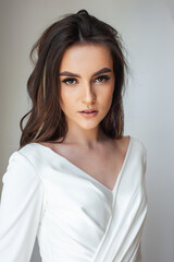 Fototapeta premium Beauty Portrait of bride wearing in wedding dress with voluminous skirt, studio photo. Young attractive bride. Smiling beautiful young bride