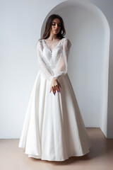 Fototapeta na wymiar The beautiful woman posing in a wedding dress