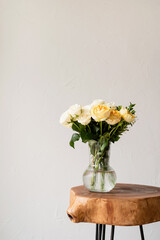 minimal home interior with stylish wooden coffee table and bouquet of fresh roses