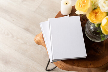 White book blank cover mockup on stylish wooden coffee table with roses bouquet, high angle view - Powered by Adobe
