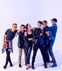 Fototapeta premium Group of six young boy and girl friends hugging and fooling around and laughing on a white background with blue light