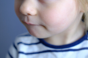 sad child, girl 2 years old, close-up of part of child's face, children's mouth, concept of sensory...