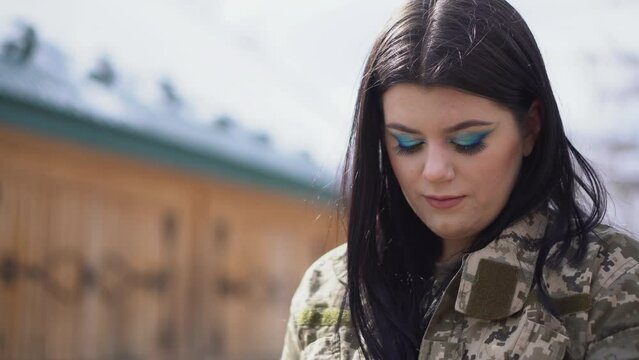 Brunette girl in military camouflage uniform. The shrewd look of a girl.