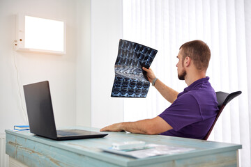 The physiotherapist doctor examining X-ray or mri picture in privat clinic. Surgeon or orthopedic...