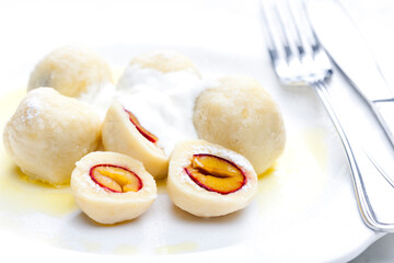 plum dumplings with sour cream, powder sugar and melted butter