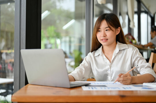 Female office worker using laptop computer, sitting in the coffee shop. remote working concept