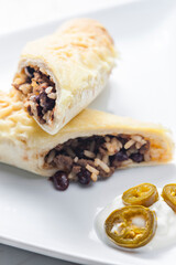 beef burrito with rice and beans served with whipped cream and jalapenos