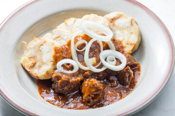 beef goulash with onion rings and dumplings