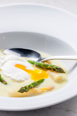 white and green asparagus soup with poached egg