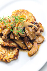 chicken meat with mushroom sauce served with potato pan cakes