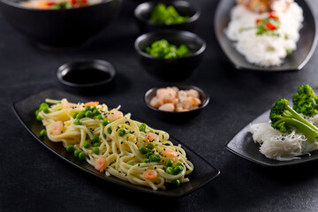 Various dishes of Asian cuisine with different types noodles and rice with shrimp, duck, vegetables and black sesame