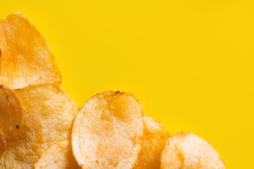 top view of delicious, crunchy and salty potato chips on yellow