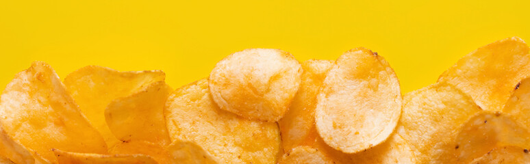 top view of delicious, crunchy and salty potato chips on yellow, banner - obrazy, fototapety, plakaty