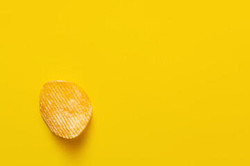 top view of single wavy and salty potato chip on yellow - obrazy, fototapety, plakaty