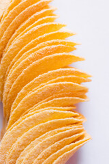 close up of salty and fried potato chips on white