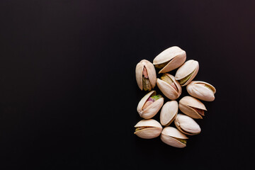 top view of cracked and salty pistachios isolated on black - obrazy, fototapety, plakaty