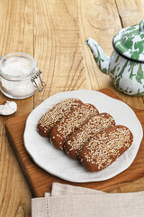 Roti Gambang or Ganjel Rel is Indonesian traditional snack with sesame seeds, flavoured with cinnamon and palm sugar. Served on white plate.
