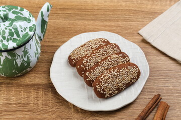 Roti Gambang or Ganjel Rel is Indonesian traditional snack with sesame seeds, flavoured with cinnamon and palm sugar. Served on white plate.
