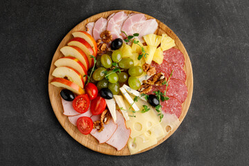 Plate with salami and cheese, nuts, apple with great background